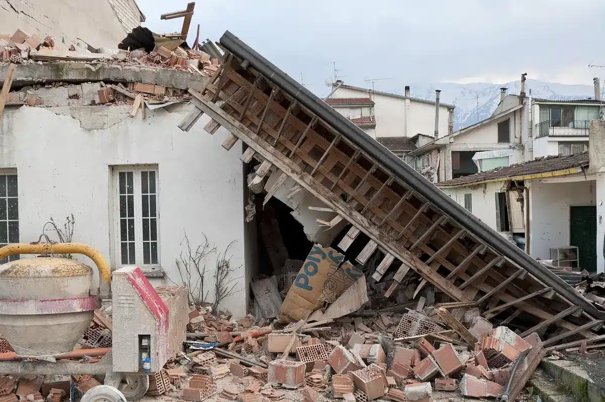Edifícios destruídos e escombros após sismo, com equipas de resgate no local