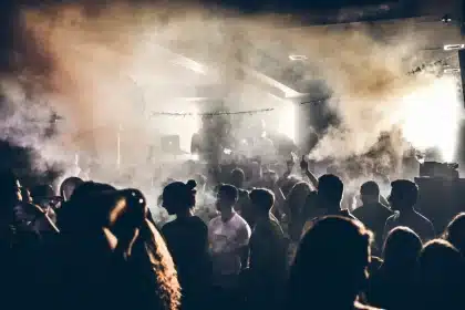 Multidão de pessoas numa festa noturna com ambiente tenso