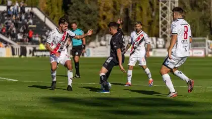 Jogadores em ação durante um jogo de futebol num estádio