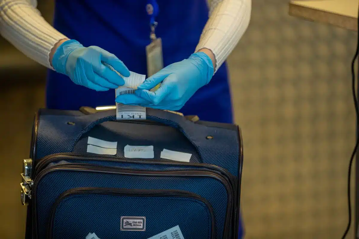 Controlo de fronteiras em terminal aeroportu&aacute;rio com oficiais de seguran&ccedil;a a verificar documentos.