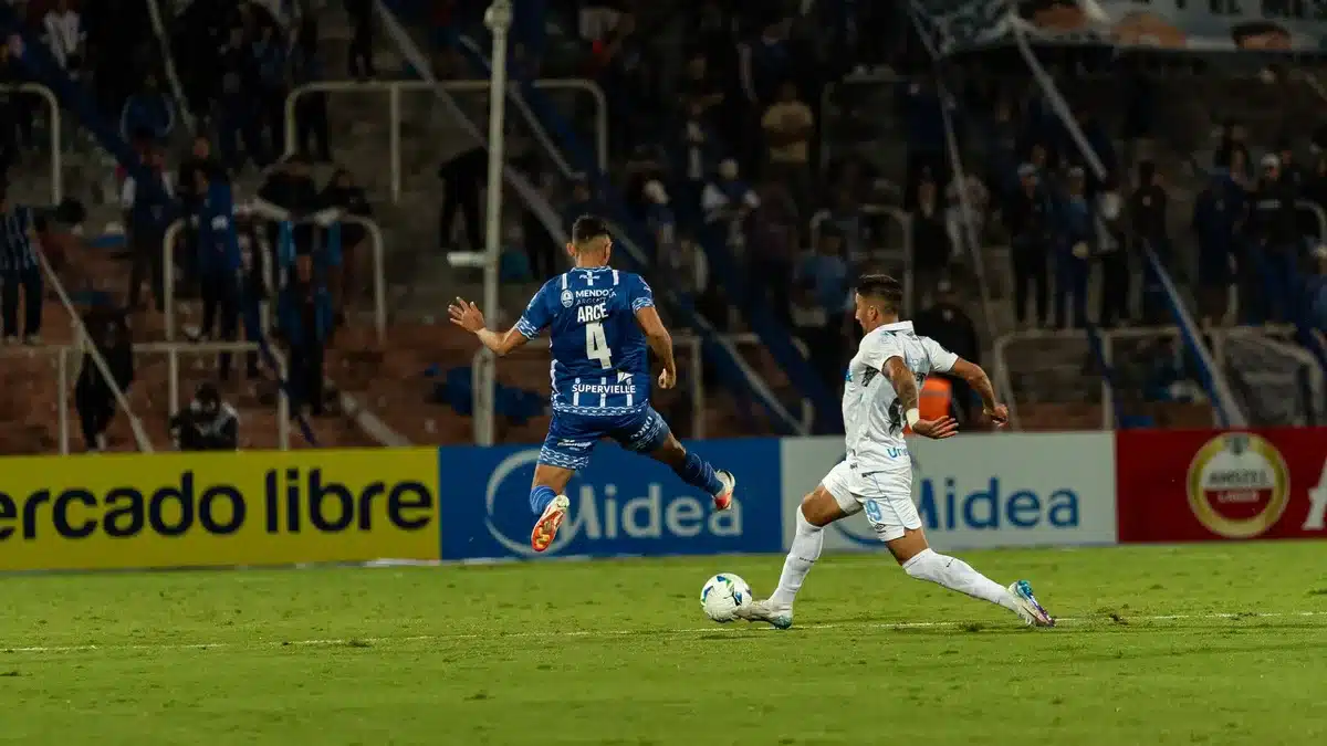 Momento de a&ccedil;&atilde;o e celebra&ccedil;&atilde;o num jogo de futebol em est&aacute;dio lotado.