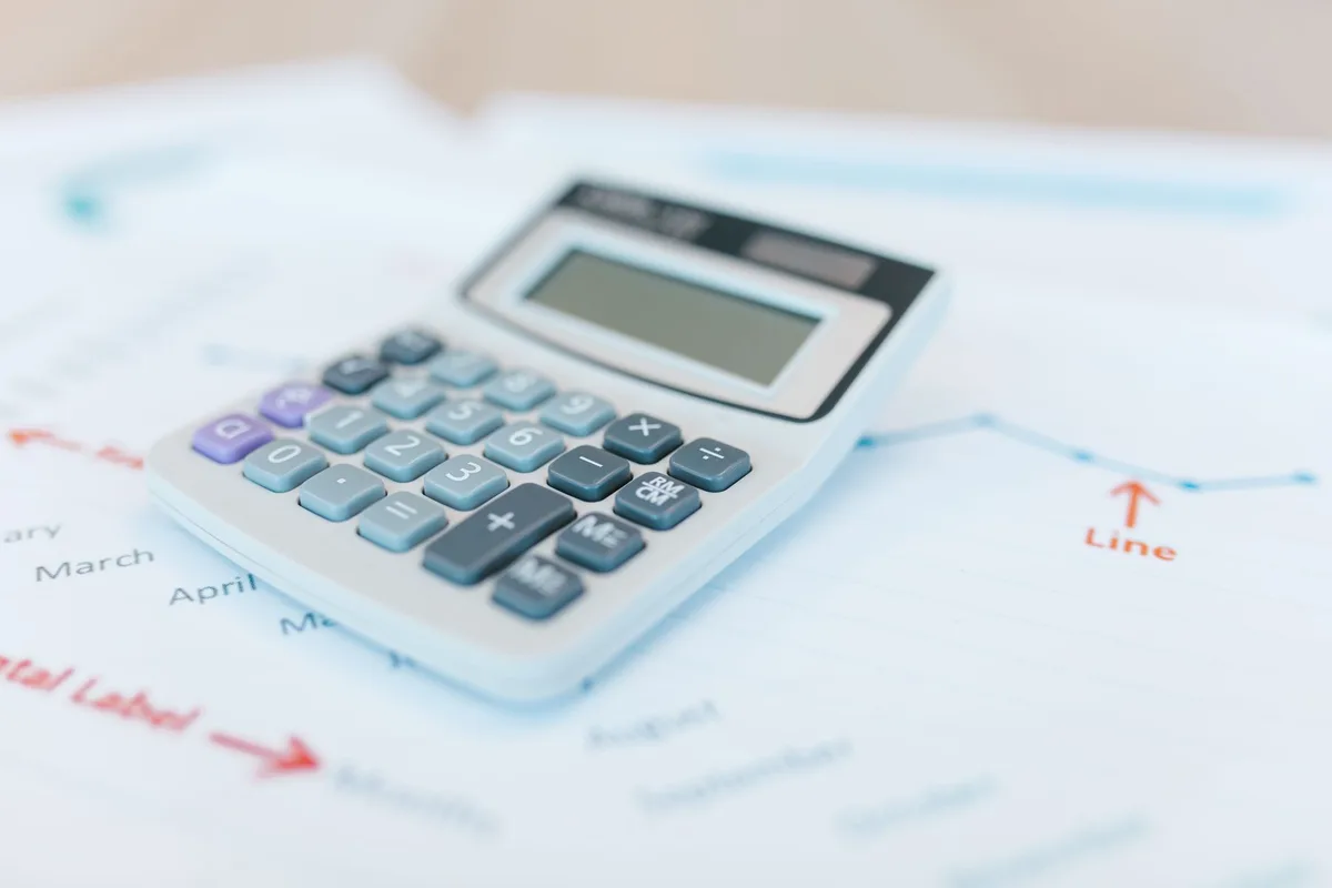 Documentos financeiros e calculadora numa secretária, simbolizando reforma de pensões