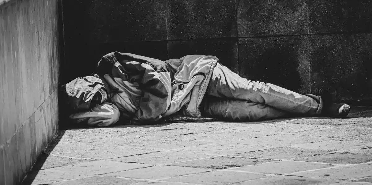 Pessoa em situação de rua num ambiente urbano sem abrigo fixo