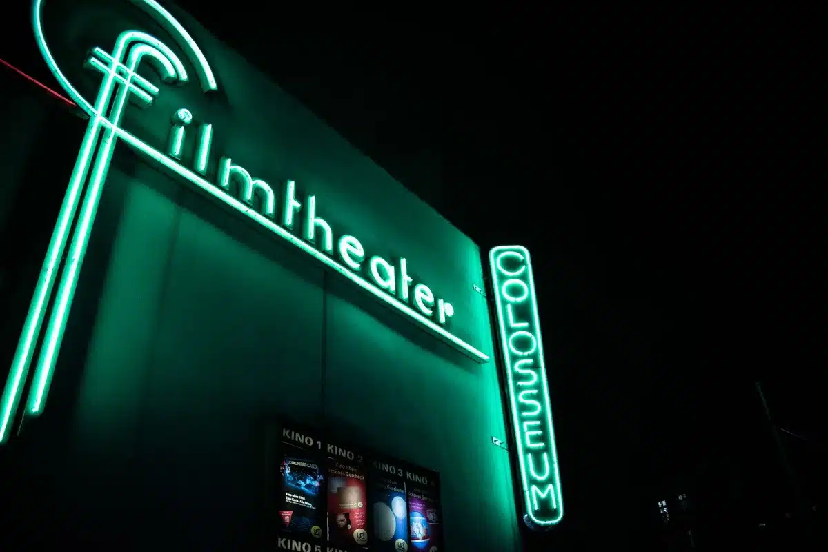 Entrada de cinema com pessoas e luzes de premiação à noite