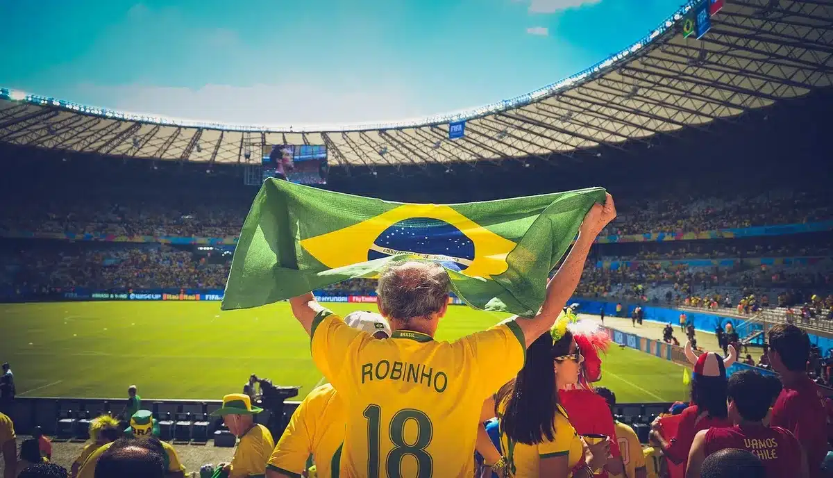 Manifestantes junto ao estádio com cartazes e bandeiras durante protesto