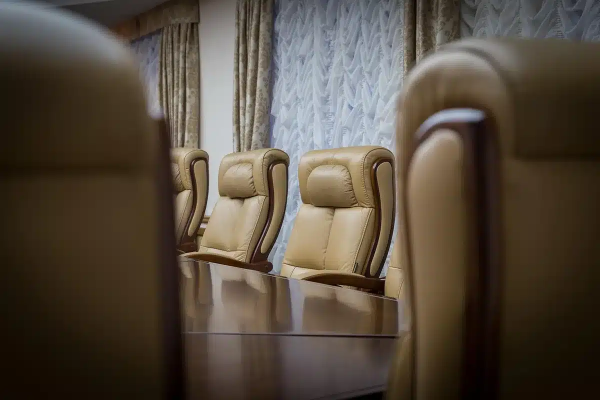 Silhuetas de membros de um conselho numa sala de reunião, simbolizando dissidência