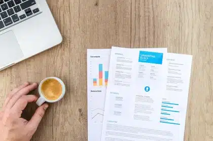 Mesa de reunião com documentos financeiros e gráficos, caneca de café ao lado