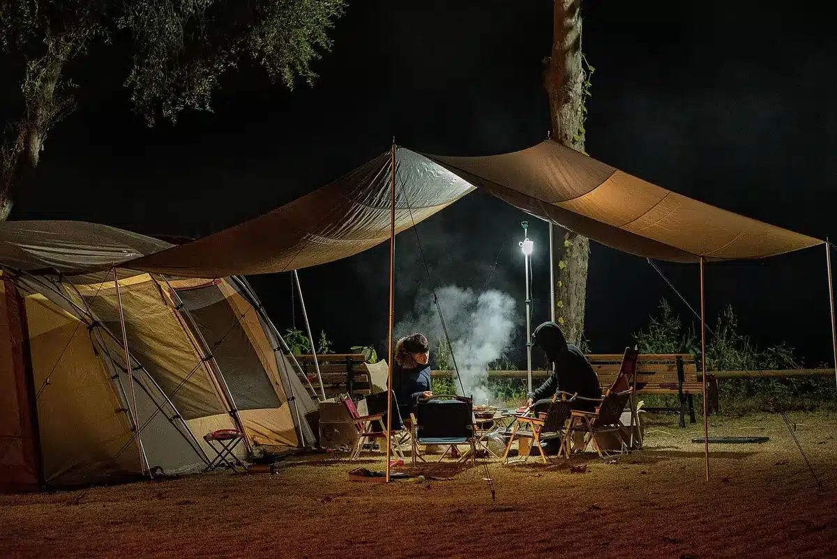 Tendas montadas num acampamento rural com pessoas ao redor