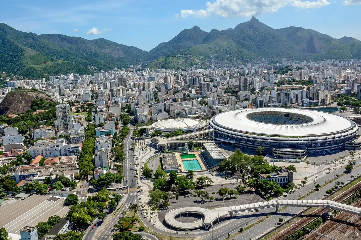 Estádio de futebol brasileiro dos anos 1950 com relva e bancos vazios