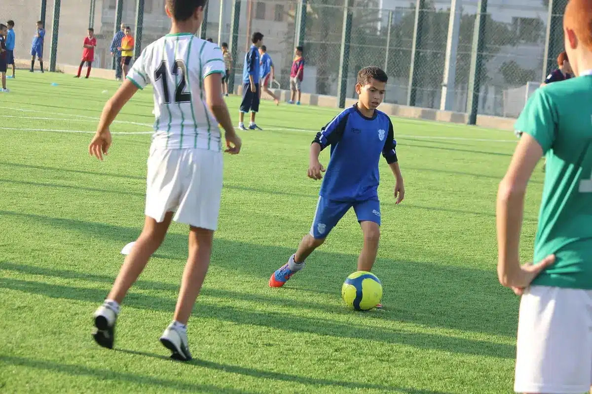 Sessão de treino com cones e jogadores anónimos no relvado