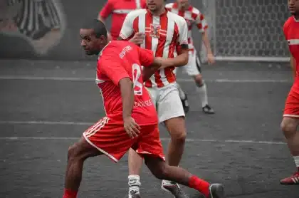 Mãos de jogadores anónimos com bolas e cones num treino de futebol