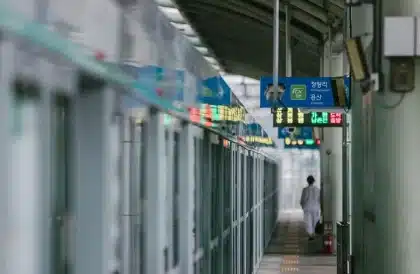 Passageiros numa estação de comboio urbana com cartão de transporte em mão