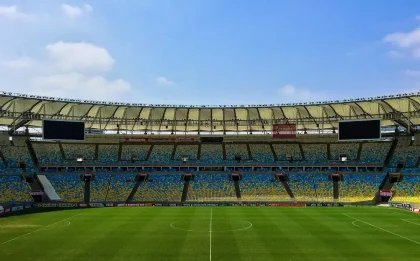 Jogador de futebol a celebrar um golo em estádio iluminado à noite