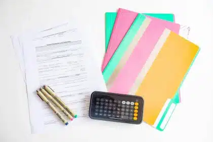 Mesa de escritório com folhas orçamentais, calculadora e pasta fechada que evocam decisões fiscais