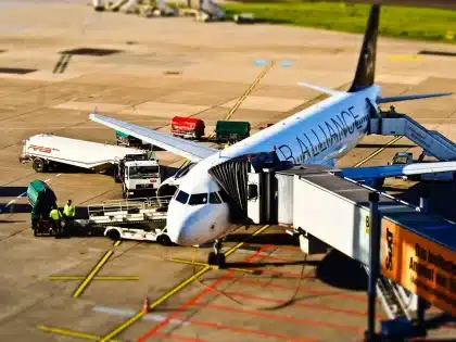 Multidão num terminal de aeroporto com dispositivo de segurança reforçado e barreiras policiais