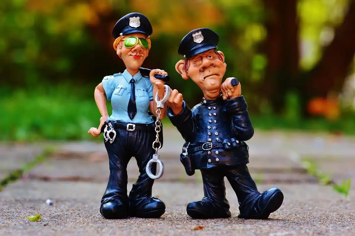 Viatura policial e técnicos anónimos junto a edifício institucional durante buscas de manhã