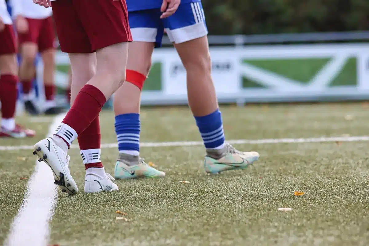 Crianças a treinar num campo escolar, representando clubes formadores