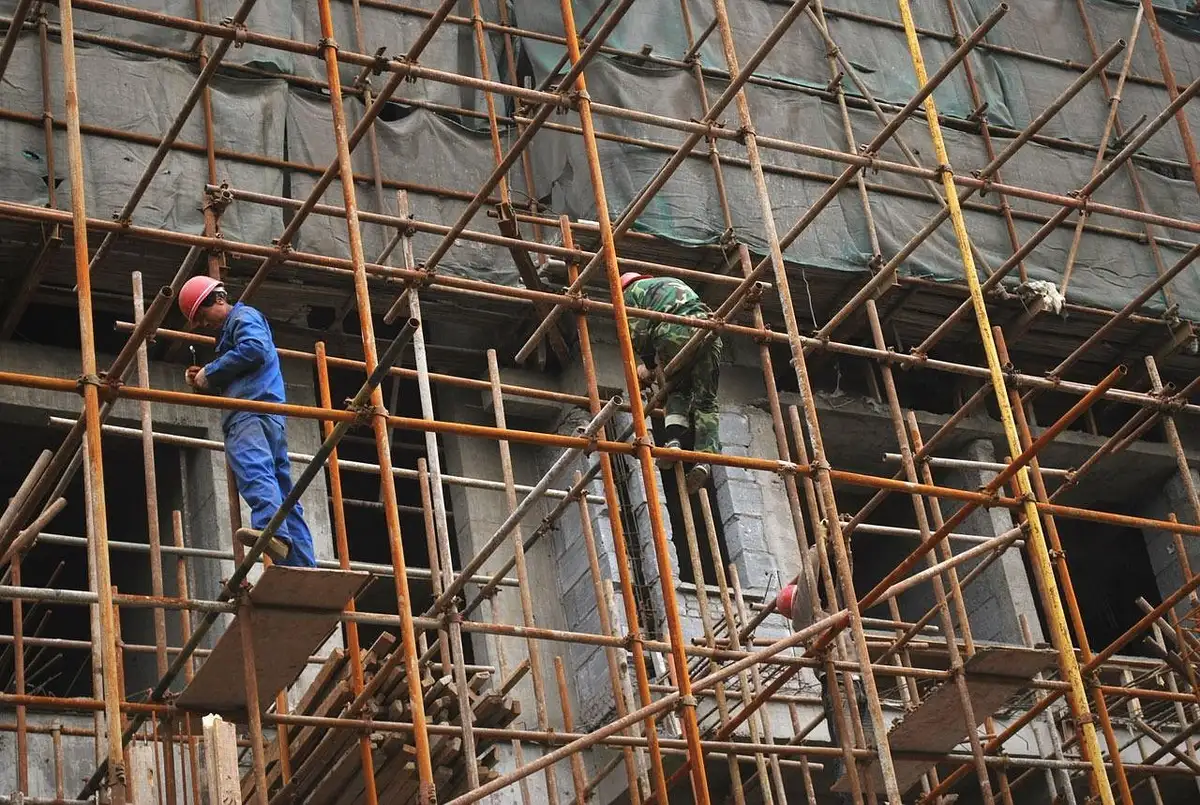 Obras de restauro num edifício histórico com andaimes e trabalhadores anónimos