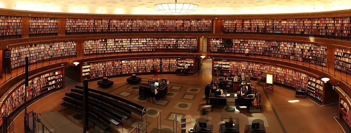 Espaço de estudo em biblioteca universitária com livros de economia e finanças