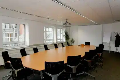 Miniatura de avião sobre mesa de reunião com documentos, mão anónima ao fundo