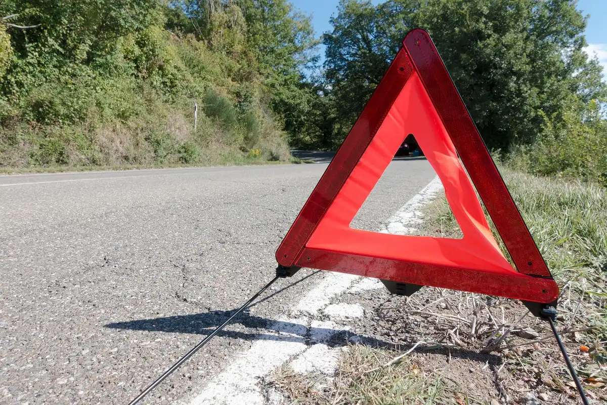 Estrada rural à noite com viaturas de emergência estacionadas e socorristas anónimos