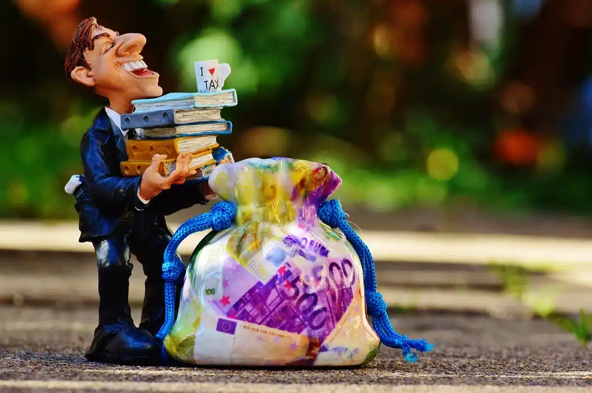 Formulários fiscais e calculadora sobre secretária a ilustrar ajustamentos de impostos