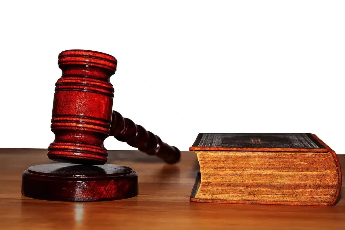 Sala de tribunal com réus e advogado durante audiência