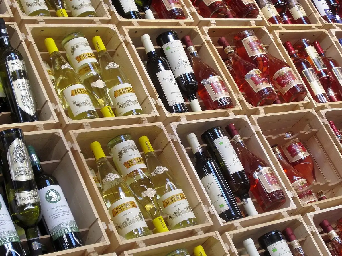 Trabalhadores carregando caixas de vinho numa adega durante a noite