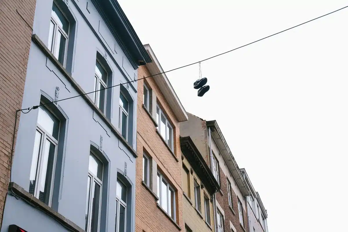 Corredor de apartamento vazio com porta entreaberta e sapatos no chão