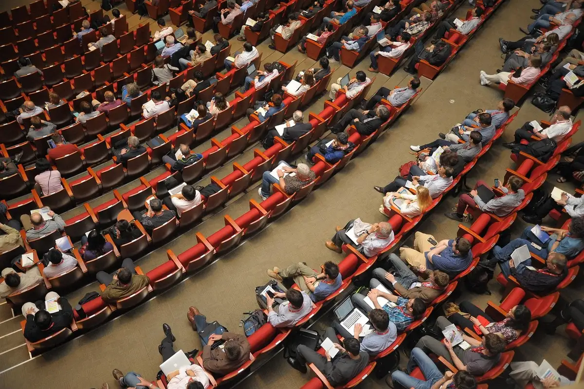 Sala de reunião antiga com documento e bandeiras genéricas representando a escolha do país‑sede