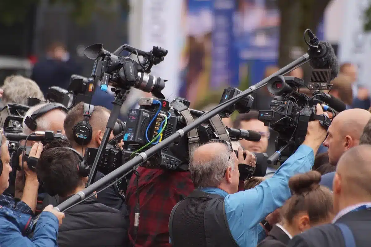 Câmaras de televisão e microfones junto a uma entrada de estádio