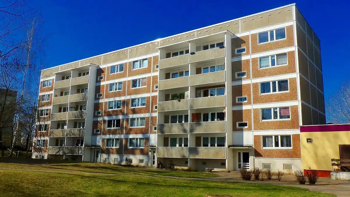 Blocos residenciais e uma mão a segurar chaves simbolizando arrendamento acessível