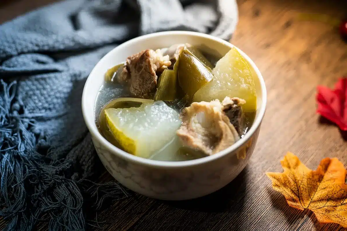 Tigela de caldo de ossos caseiro numa mesa de cozinha