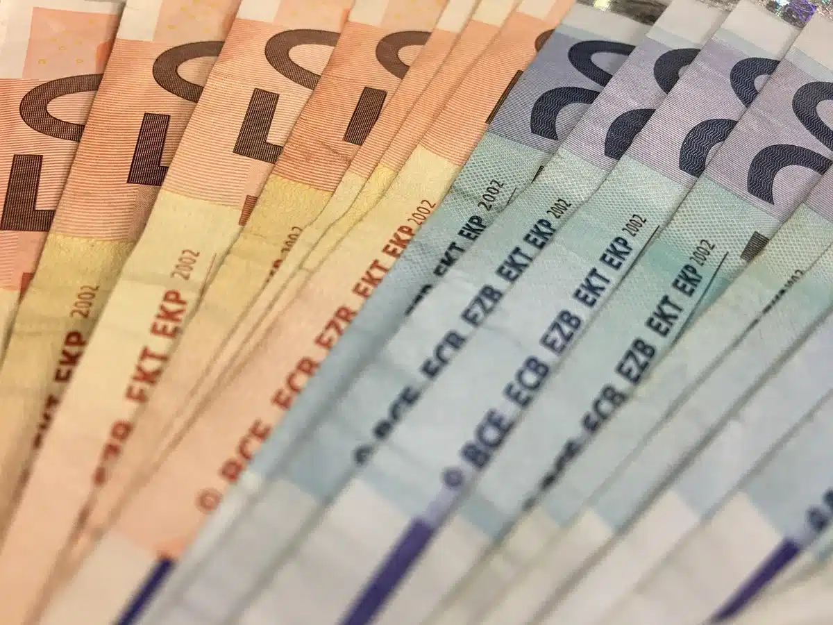 Notas de euro e envelopes representando pagamentos e valores envolvidos